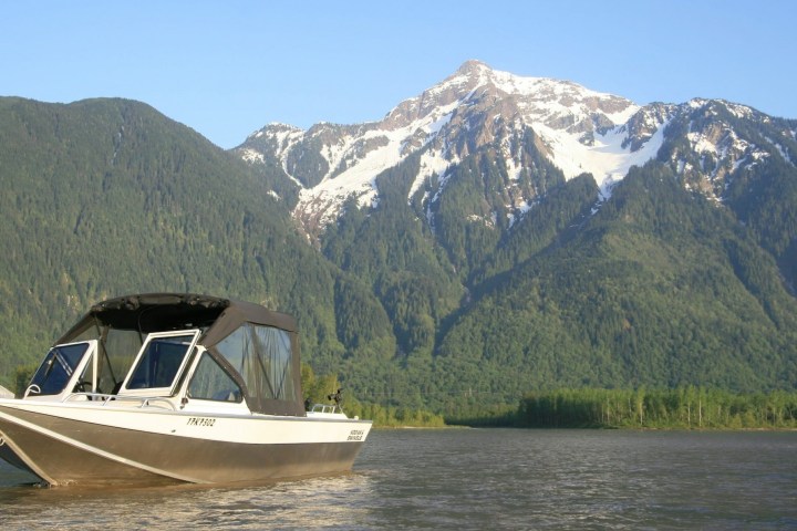 a small boat in a body of water with a mountain in the background